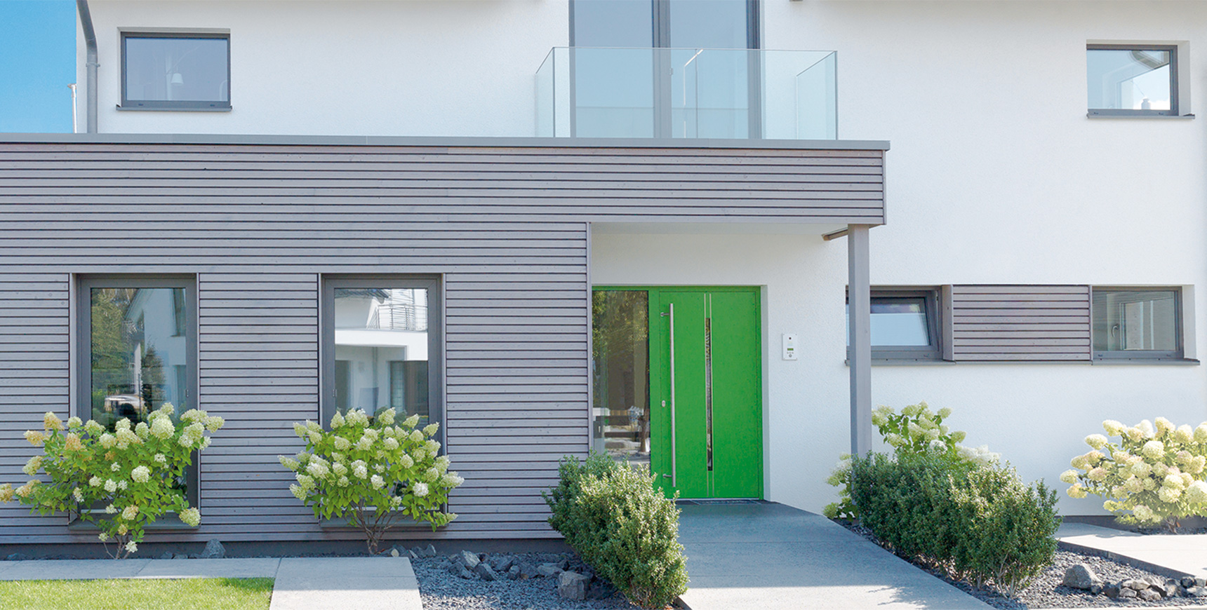 Einfamilienhaus mit grüner Haustür, Motorische Mehrfach-Verriegelungen von FUHR für Haustüren und Objekttüren: Vollmotorische, selbstständige Türverriegelungen mit Schnittstelle für SmartHome-Zutrittssystemen. 