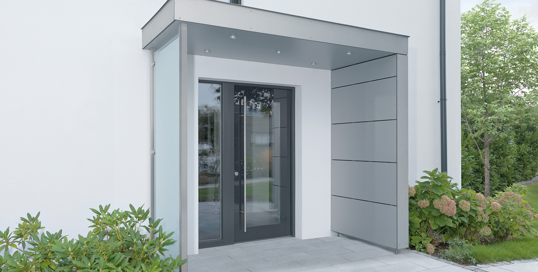 Überdachte Haustür aus Aluminium mit Glasscheibe, Schlüsselbetätigte Mehrfach-Verriegelungen von FUHR mit präzisen zweitourigen Getriebe. Für ein leichtgängiges Öffnen und Schließen von Haustüren. 