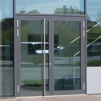 Objekt mit Glasfront und zweiflügeliger Eingangstür mit Panikgriffstange, Zuverlässige Tür-Verriegelungen speziell für den öffentlich-gewerblichen Bereich von FUHR: geprüfte Motor- und Automatikschlösser, Schlösser mit Schlüssel- und Drückerbetätigung für Objekt- oder Funktionstüren.