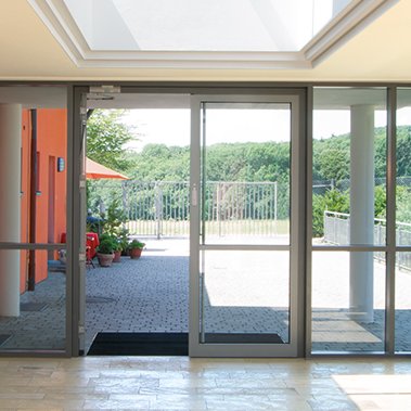 Zweiflügelige Eingangstür aus Aluminium eines Gewerbeobjektes. FUHR Verriegelungen und Rahmenteile speziell abgestimmt auf die Anforderungen von Aluminium- und Stahltüren. 